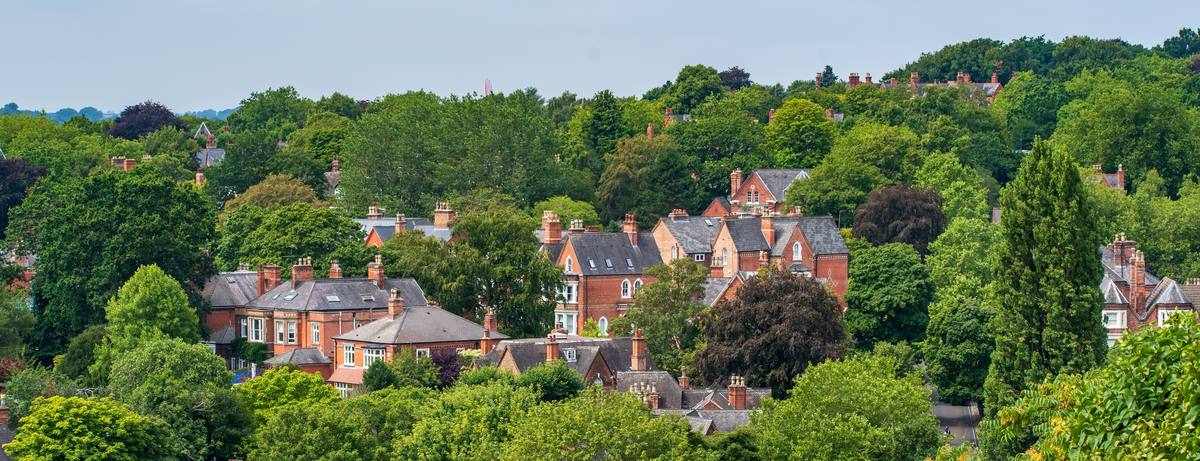 Victorian red-brick houses among trees on a wooded hillside